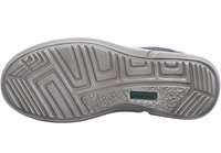 Šedá guma podešve boty s texturovaným vzorem, obsahující hluboké drážky a hladkou plochu, označená malým zeleným logem.