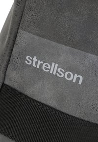 Črna platnena torba z teksturirano površino, ki ima sivo "strellson" logo in debel črn trak vzdolž spodnjega dela.
