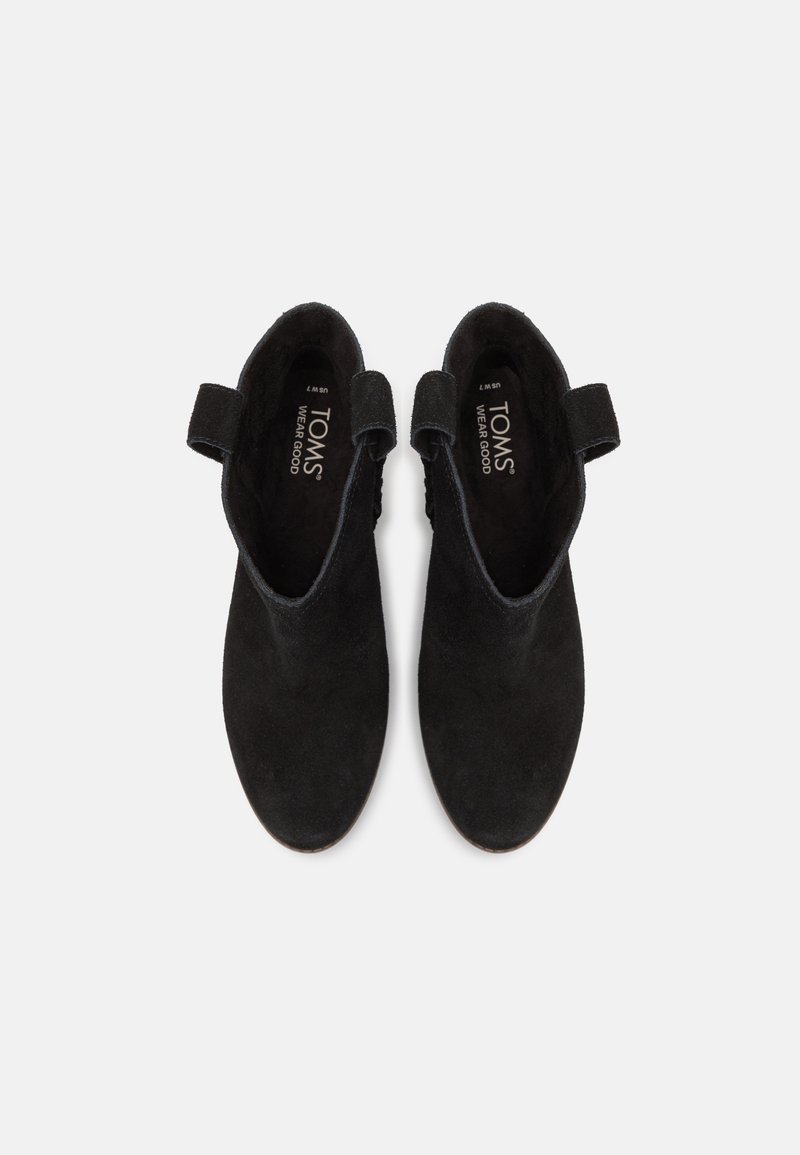 Stivaletti neri in suede con punta rotonda, anelli laterali per una facile calzata e logo impresso sulla soletta. Texture liscia e design minimalista.