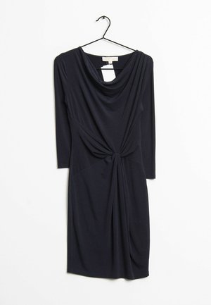 Schwarzes, langärmeliges, knielanges Kleid mit drapiertem Ausschnitt und gedrehtem Knoten-Detail an der Taille, hängend an einem schwarzen Kleiderbügel vor weißem Hintergrund.