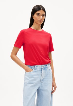 Rotes Baumwoll-T-Shirt mit kurzen Ärmeln, Rundhalsausschnitt und lockerer Passform, kombiniert mit hellblauen hoch taillierten Jeans. Glatte Textur, ohne Muster.