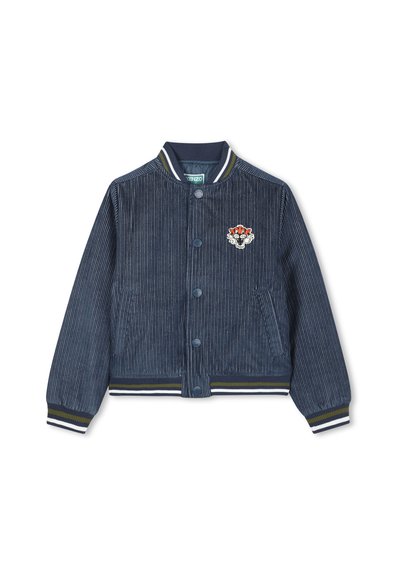 Veste bomber en velours côtelé bleu marine avec col, poignets et ourlet côtelés rayés en blanc et vert olive, présentant un petit visage de tigre brodé sur la poitrine.