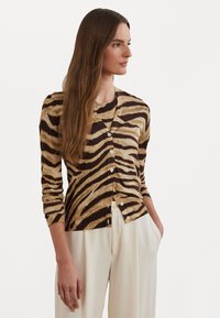 Gehaakte cardigan in bruin en beige tijgerstrepen, met lange mouwen, een ronde halslijn en een sluiting met knopen aan de voorkant. Zachte, gewatteerde stof.