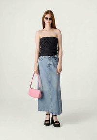 Black strapless top, light blue denim maxi skirt, pink handbag, and black platform sandals. Sleek design with smooth textures.