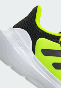 Schwarzer und neongrüner Sportschuh mit einem Obermaterial aus Mesh, einer strukturierten weißen Mittelsohle und einer Gummi-Außensohle mit "CLOUDFOAM"-Branding.