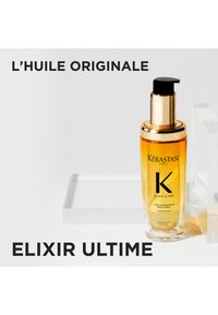 Kérastase Elixir Ultime haarolie in een doorzichtige fles met een gouden pompje en dop. De vloeistof is amberkleurig. Tekst bevat "L'Huile Originale."