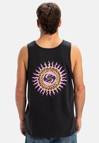 Top negro sin mangas que presenta un gráfico circular de sol en tonos rosa y dorado en la parte posterior. La tela parece suave y tiene un corte relajado.