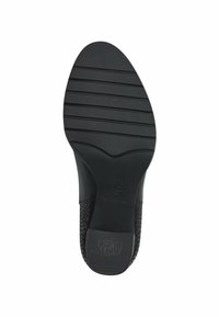 Semelle de chaussure noire avec une surface texturée, présentant des rainures horizontales et un logo embossé près du talon. Matériau lisse avec un accent à motif.