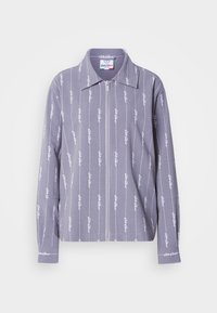 Ανοιχτό γκρι πουκάμισο μακρυμάνικο με ίσια ραφή στο κάτω μέρος, φερμουάρ στο μπροστινό μέρος και επαναλαμβανόμενο μοτίβο λευκού λογότυπου. Διαθέτει γιακά και μανσέτες με κουμπιά.