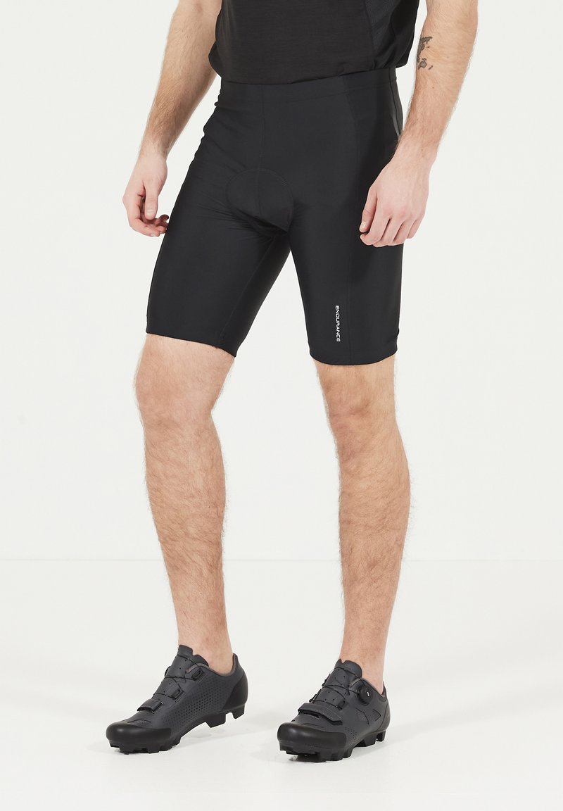 Shorts de compression noirs avec une texture lisse, dotés d'un insert rembourré et d'une coupe ajustée. Accompagnés de chaussures de cyclisme noires avec des semelles durables.
