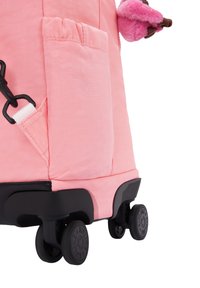 Borsa con ruote rosa, con un esterno in tessuto liscio, base in plastica nera, molteplici tasche e piccole ruote in gomma per una facile mobilità.