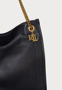 Musta nahkainen käsilaukku, jossa on teksturoitu pinta, kultaketjuolkaimet ja kultainen 'RL' logo-helle kiinnitettynä etuosaan.