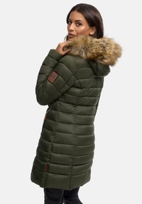 Padded green parka with a fur-lined hood, featuring a quilted design and side pockets, accented by a brown leather patch on the shoulder.
