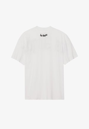 Biela bavlnená tričko s krátkymi rukávmi a okrúhlym výstrihom, s čiernou výšivkou "Los Angeles" na golieri. Jednoduchý dizajn.