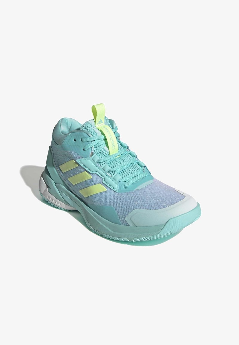 Chaussure de sport turquoise avec dessus en mesh, détails texturés et trois bandes réfléchissantes. Lacets et languette en vert clair.