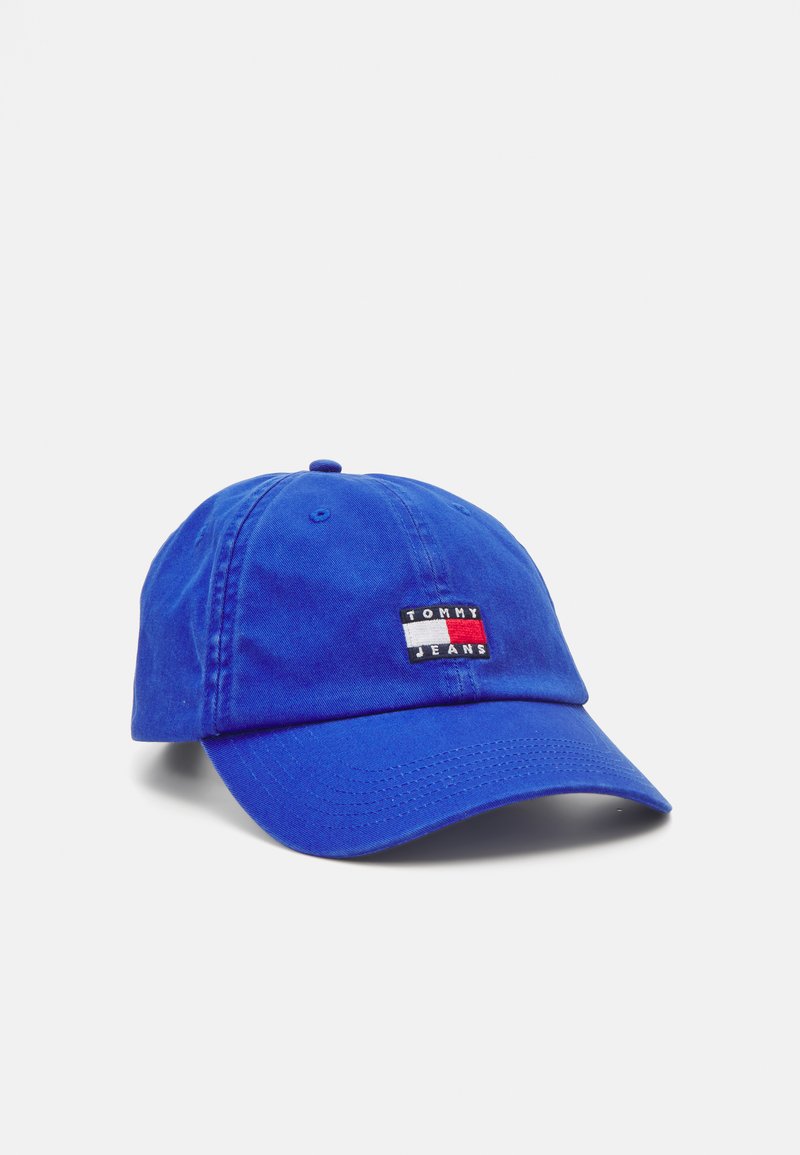 Spilgti zils kokvilnas beisbola cepure ar noapaļotu vizieri, kurai ir taisnstūrveida logo plāksne sarkanā, baltā un melnā krāsā ar uzrakstu "TOMMY JEANS".