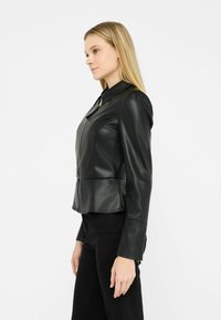 Černá koženka s zipem vpředu, strukturovanými rameny a peplum hem. Hladká textura a elegantní design.