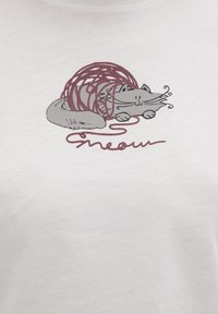 White t-shirt featuring a printed illustration of a gray cat enveloped in red yarn. Text below the image reads "meow" in a cursive style.