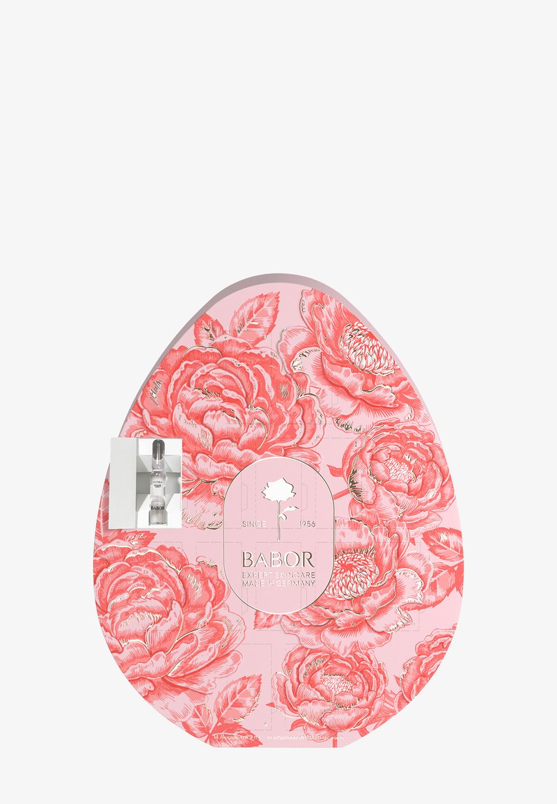 Boîte rose en forme d'œuf avec des motifs floraux corail, contenant des ampoules de soin Babor, étiquetée "Soin expert fabriqué en Allemagne."