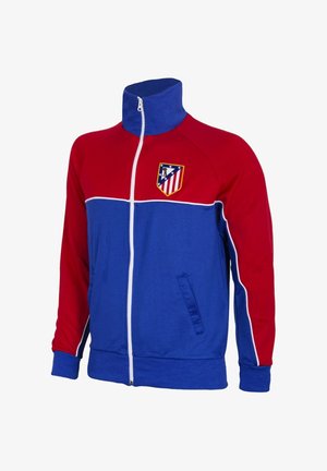 Rood-blauwe sportjas met ritssluiting, witte bies en het embleem van voetbalclub Atlético Madrid op de borst.