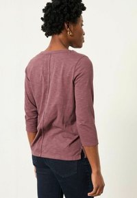 Long-sleeve top in mauve, with a relaxed fit, round neckline, and slits at the hem. Soft texture with a subtle heather effect.