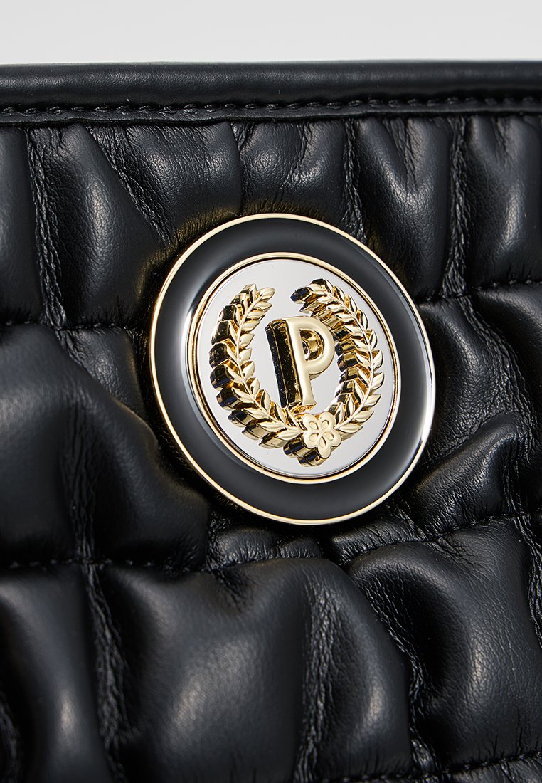 Pelle in pelle nera trapuntata con un emblematico design in oro, caratterizzato da foglie di alloro e dal logo 'P', posizionato su una base circolare elegante.