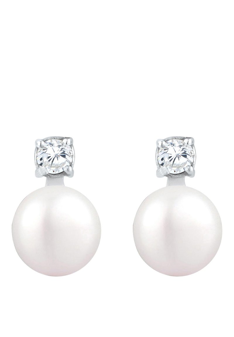 Boucles d'oreilles en perles avec une base en perle ronde blanche et un bijou rond transparent au-dessus, montées en métal argenté.