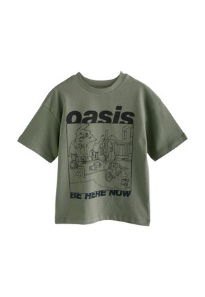 T-shirt vert olive avec une illustration en ligne de scène de rue comprenant des personnes, des arbres, et le texte "oasis Be Here Now."