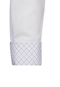 Polso di camicia bianco con un motivo azzurro chiaro e dettagli rossi, forme a diamante e una texture liscia.