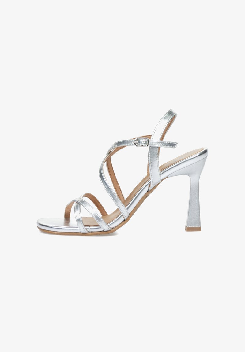 Sandalias de tacón alto plateadas con múltiples tiras entrelazadas, diseño de punta abierta y una plantilla texturizada. Tacón robusto y cuadrado para mayor soporte.