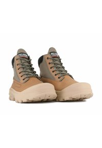 Tan and gray waterproof hiking boots with a sturdy rubber sole, thick laces, and textured fabric accents. Features a padded collar and logo.