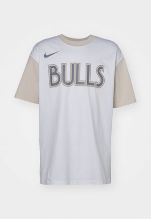 White cotton t-shirt with beige short sleeves. Features "BULLS" in bold, dark gray letters. Nike logo in navy on the left shoulder.