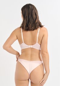 Pink satin BH- und String-Set, mit verstellbaren Trägern, weichem Material und glatter Oberfläche, das ein nahtloses Design betont.
