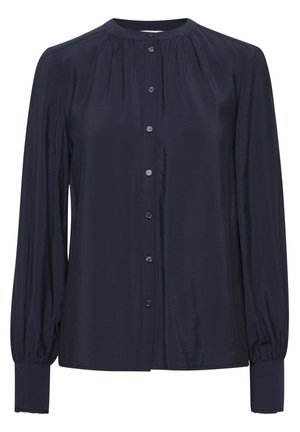 Mörkblå blus med lång ärm och knappstängning, rund hals, smockdetaljer vid axlarna och åtsittande manschetter. Slät tygkvalitet.