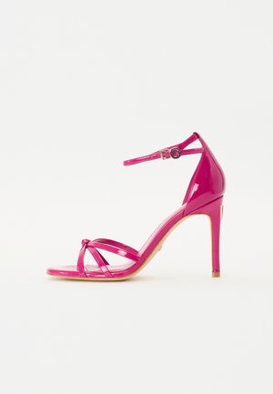 Roosa patendiga nahast kõrgendatud sandaalid, millel on pahkluuraud, ristuvad varba rihmad ja peenike stilettokand.