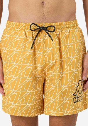 Pantaloni da bagno gialli con un motivo astratto bianco, vita elastica e laccetto nero. Presenta un logo nero sul lato sinistro in basso.