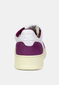 Sneaker in pelle bianca con tacco in suede viola, suola crema e logo impresso sul tacco. Forma arrotondata con dettagli cuciti.