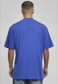 Krótki rękaw, luźna koszulka z bawełny w intensywnym niebieskim kolorze, z okrągłym dekoltem i prostym, gładkim wzorem z tyłu.