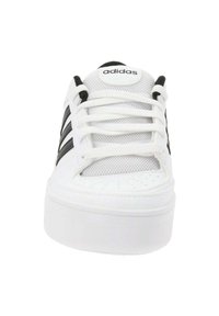 Białe buty sportowe z siateczkową cholewką, czarnymi paskami i okrągłym noskiem. Posiadają białe sznurowadła i wyściółkę języka. Gruba biała gumowa podeszwa.