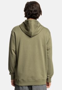 Olijfgroene hoodie met een kangoeroezak, verstelbare trekkoordkap, ribgebreide manchetten en zoom. Zacht, gestructureerd materiaal met een relaxte pasvorm.