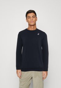 Marineblauwe sweatshirts met lange mouwen en een ronde hals. Heeft een klein logo op de linkerborst. Glad materiaal en reguliere pasvorm.
