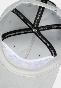 Gorra gris con un exterior de tela suave, banda de malla blanca y forro interior negro con texto. Diseño sencillo con una corona redonda y correa ajustable.