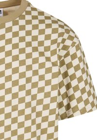 T-shirt à manches courtes à carreaux, présentant un motif alterné de carrés verts olive et crème, fabriqué en tissu de coton doux avec un col rond.