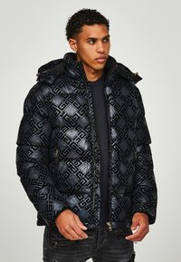 Black puffer jacket with a quilted design, featuring a geometric pattern, hood, and zippered front closure. Material appears glossy and textured.