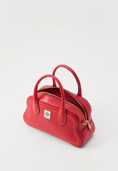Sac à main en cuir rouge avec deux poignées enroulées, fermeture éclair dorée, quincaillerie dorée et coutures blanches. Forme rectangulaire avec une étiquette de marque.
