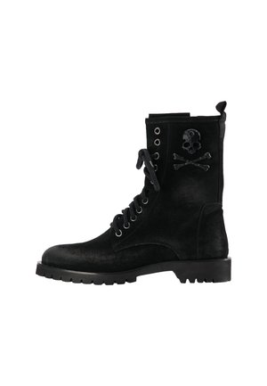 Melnas zamšādas šņorējamas kaujas zābaki ar biezām zolēm un galvaskausa un krustiņu emblēmu uz potītes daļas.