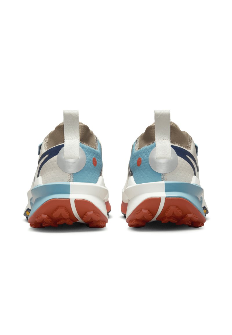 Scarpe da ginnastica azzurro chiaro con tomaia in rete, suola rossa e dettagli bianchi. Presentano un tallone imbottito, un'elastico per il rilascio e design contrastanti su ciascuna scarpa.