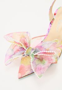 Chaussure slingback à bout pointu avec imprimé floral, ornée d'un grand nœud transparent avec bord en perles, dans des couleurs pastel douces. Matériau lisse et design élégant.