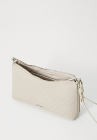 Pochette beige, testurizzata, con chiusura a zip e tracolla removibile. Contiene un interno liscio con marchio. Design rettangolare e sottile.