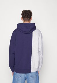 Sweatshirt met capuchon in een kleurblokdesign in marineblauw en lichtgrijs, met een losse pasvorm en geribbelde manchetten.